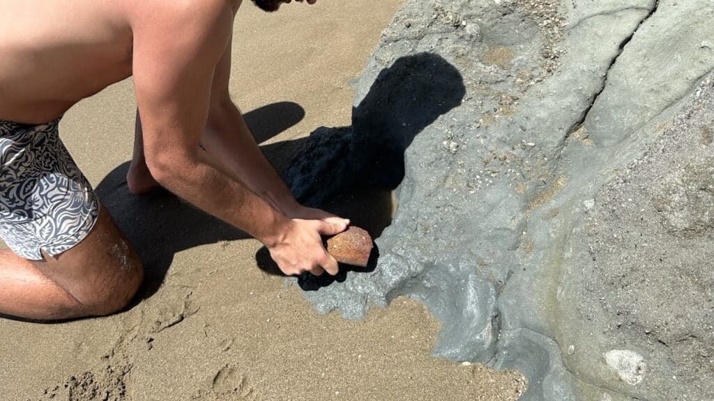 Getting clay off the rocks of Kalogeros Beach in Paros Greece